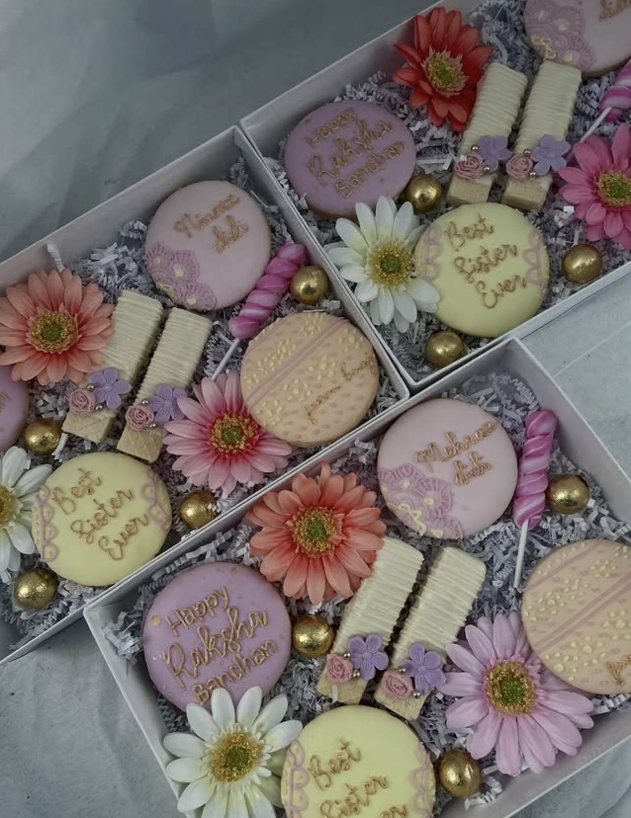 Raksha Bandhan custom cookie box with purple and cream cookies, gerbera daisies, and gold pearl accents