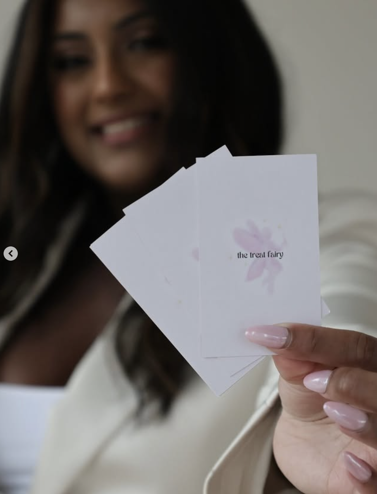 Alissa holding The Treat Fairy branded business cards — brand portrait